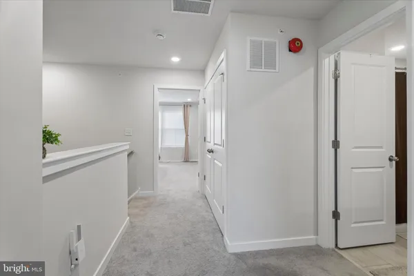 a view of a hallway with closet and wooden floor