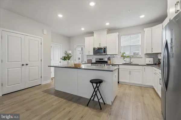 a kitchen with a sink a refrigerator and white cabinets