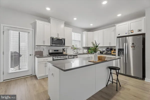 a kitchen with stainless steel appliances granite countertop a refrigerator stove microwave and sink