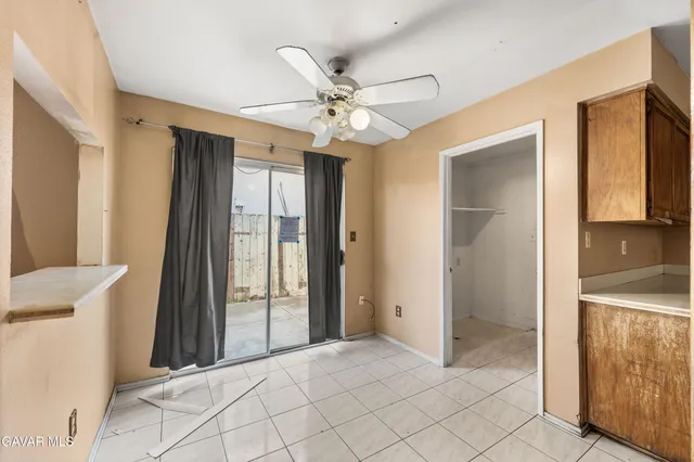 a view of a livingroom with a ceiling fan & entryway