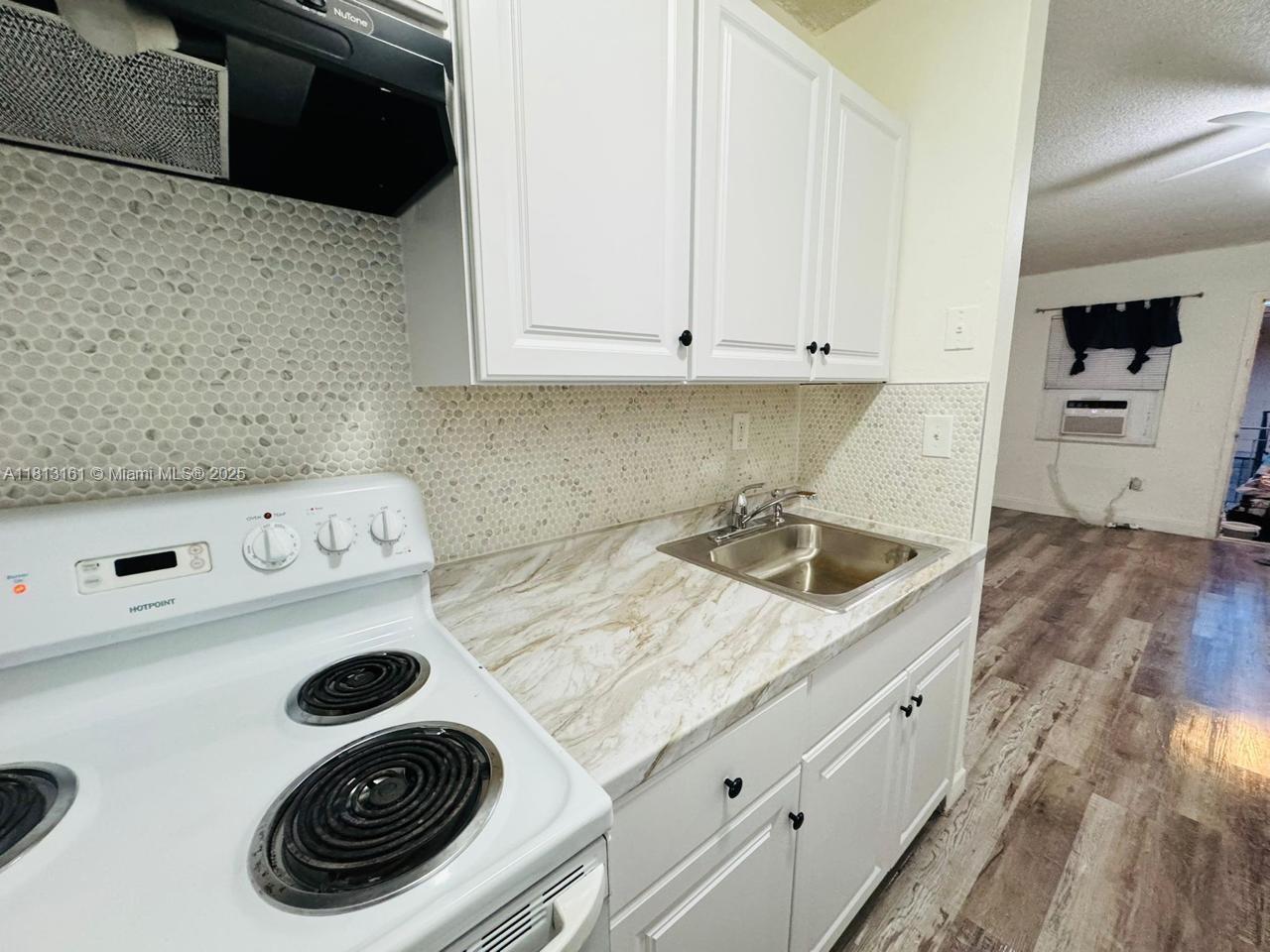 932 Northwest 5th Street, Unit 4 Miami, FL 33128 - Photo 11 of 16 a kitchen with a stove and a microwave