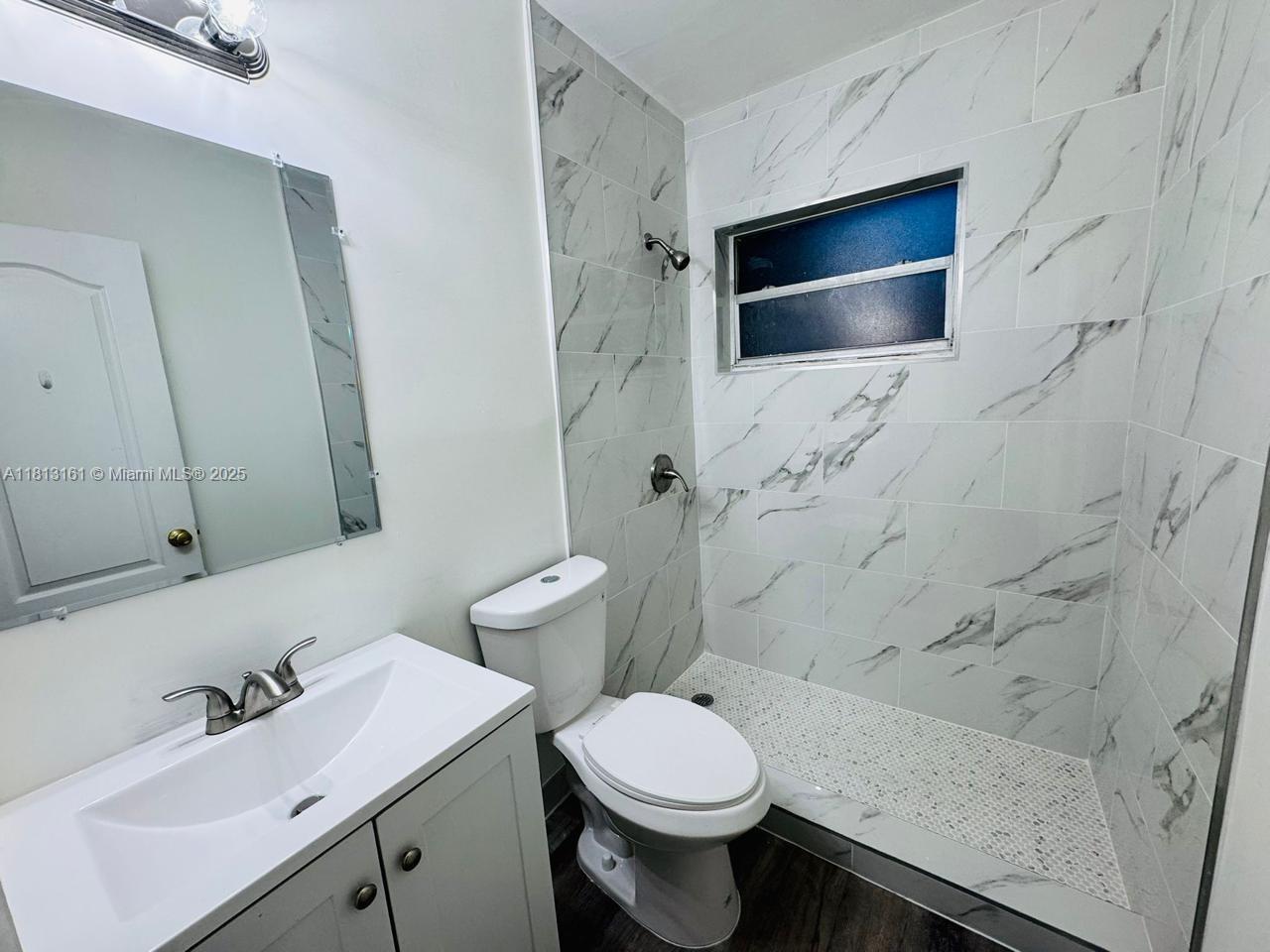 932 Northwest 5th Street, Unit 4 Miami, FL 33128 - Photo 6 of 16 a bathroom with a sink toilet and shower