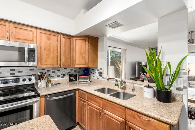 a kitchen with a sink a counter appliances and cabinets