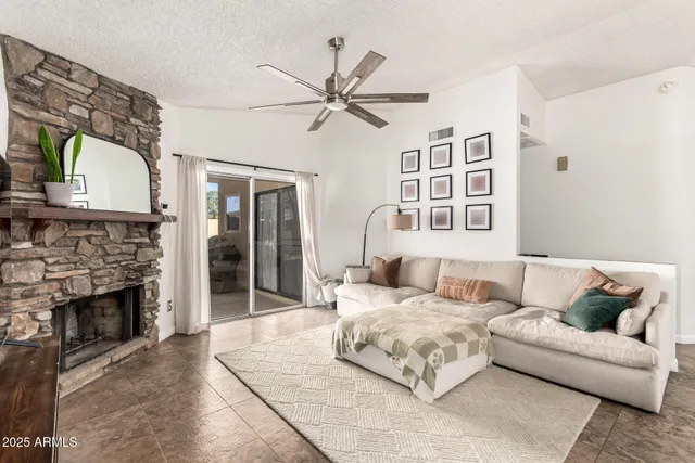 a living room with furniture a fireplace and a flat screen tv