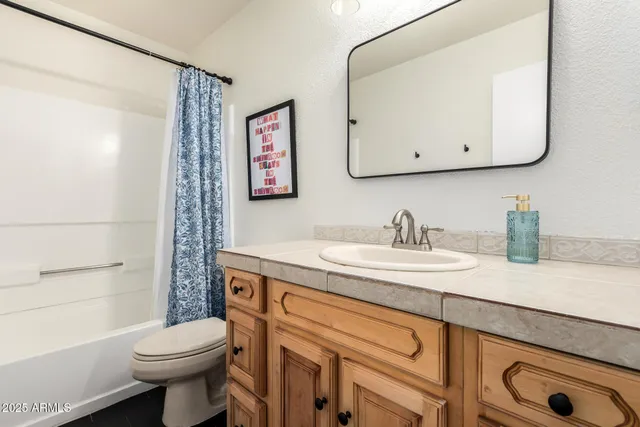 a bathroom with a granite countertop sink mirror vanity and toilet