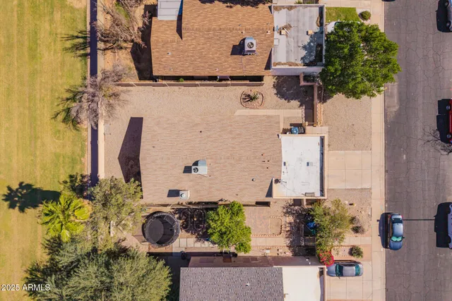 an aerial view of a house with a yard and large trees