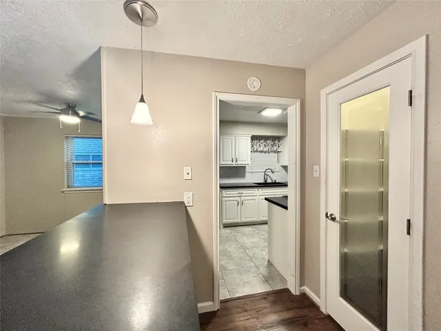 a view of a hallway with wooden floor a bathroom and a sink