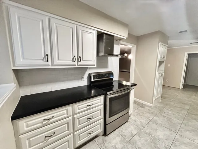 a kitchen with granite countertop a stove microwave and sink