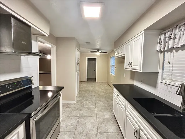 a kitchen with granite countertop a stove and a sink