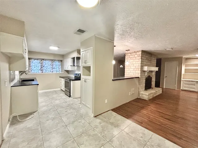 a kitchen with granite countertop a refrigerator and a stove top oven