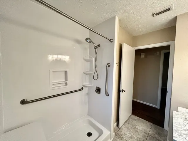 a bathroom with a glass shower door and a sink
