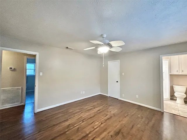 a view of a room with wooden floor and fan