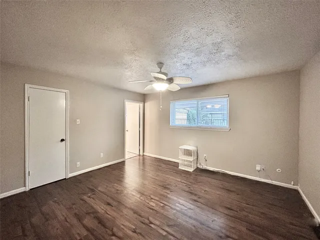 a view of a livingroom with wooden floor and a ceiling fan