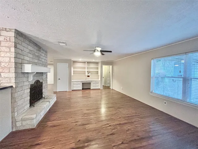 a view of an empty room with a kitchen and a window