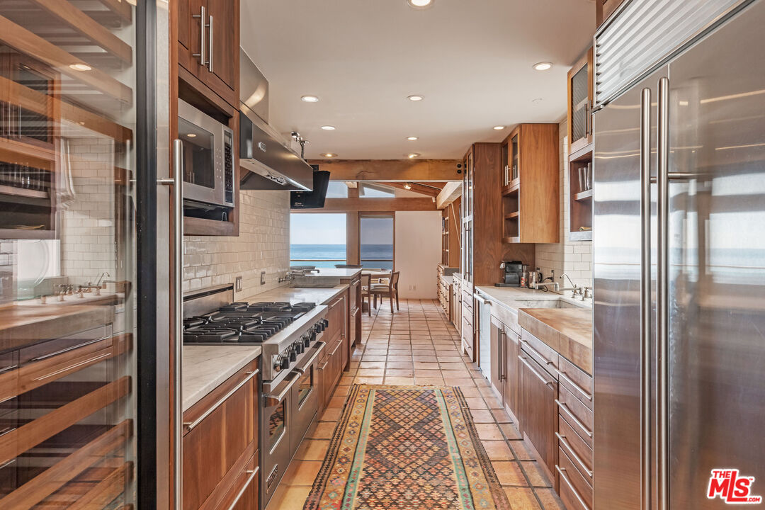 22148 Pacific Coast Highway Malibu, CA 90265 - Photo 13 of 28 a kitchen with stainless steel appliances granite countertop a stove and a refrigerator