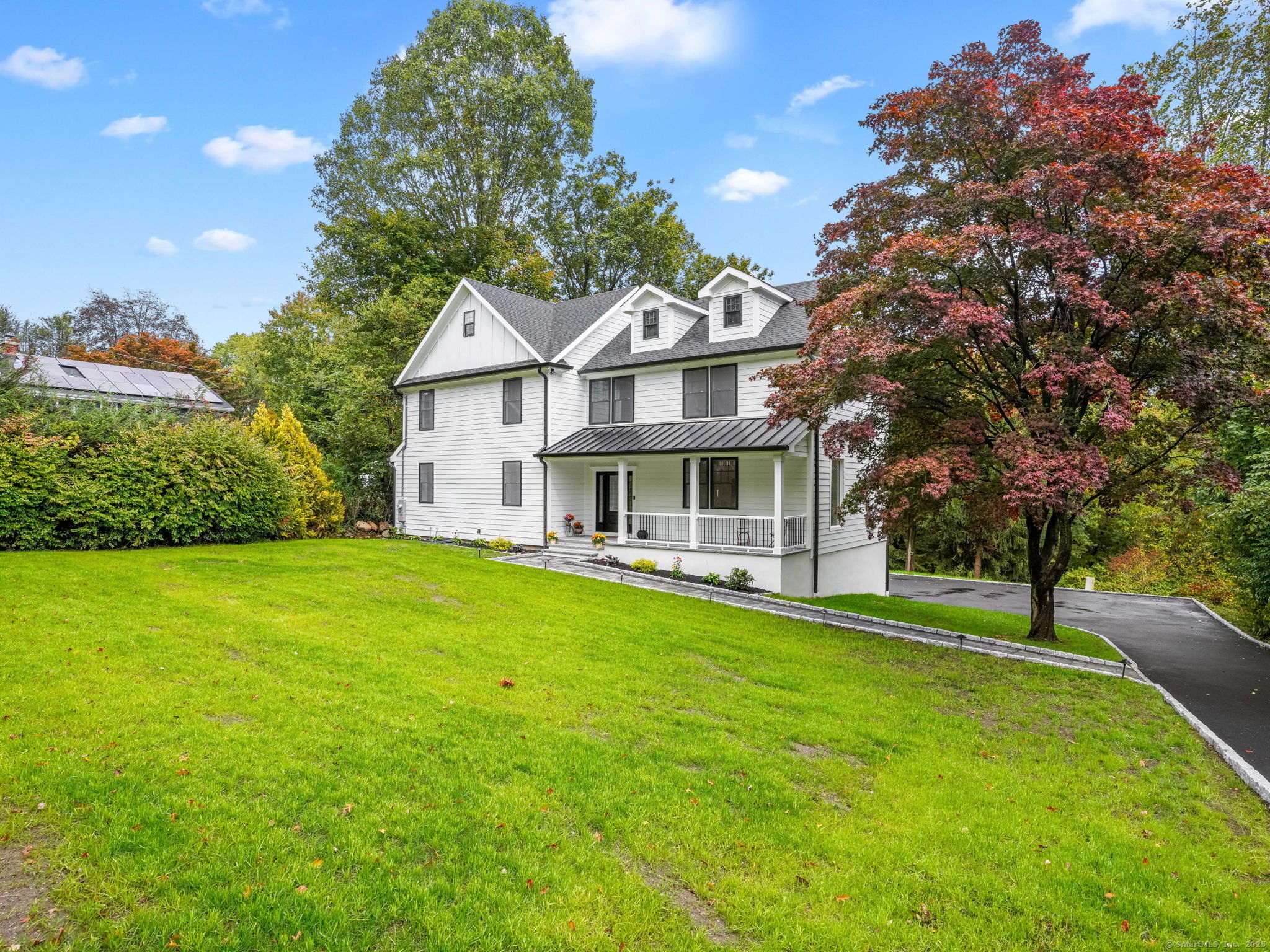 a view of a house with a big yard plants and large trees