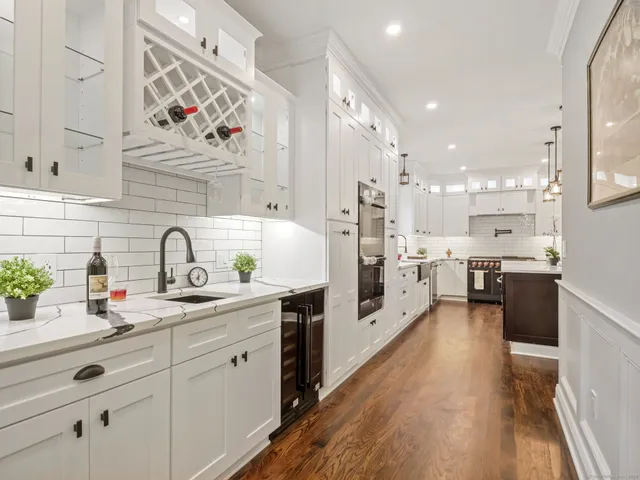 a kitchen with stainless steel appliances sink white cabinets and wooden floor
