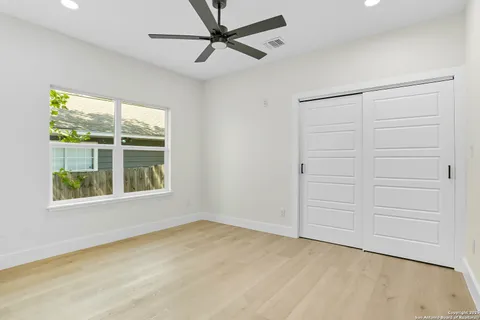 an empty room with a window and ceiling fan
