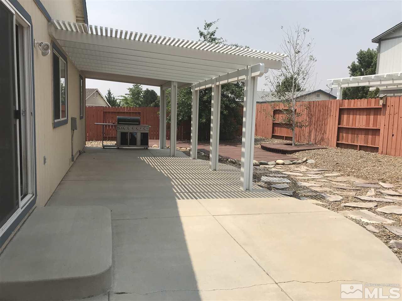 17891 Brushland Drive Reno, NV 89508 - Photo 25 of 25 a view of a patio with table and chairs a barbeque with wooden fence