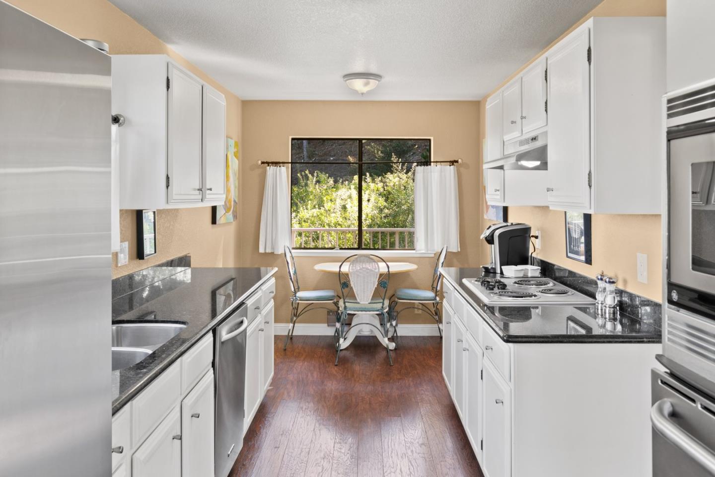 4 Shepherds Knoll Road Monterey, CA 93940 - Photo 14 of 28 a kitchen with stainless steel appliances granite countertop a stove top oven a sink dishwasher and a refrigerator with wooden floor