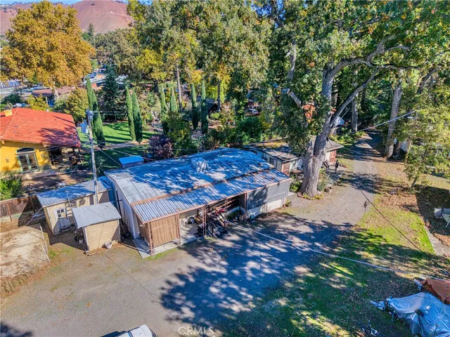 a view of a backyard with wooden fence and a tree