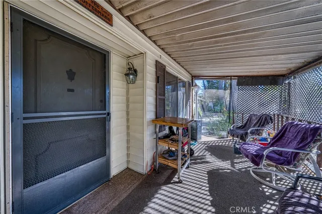 a view of a balcony with furniture and floor to ceiling window