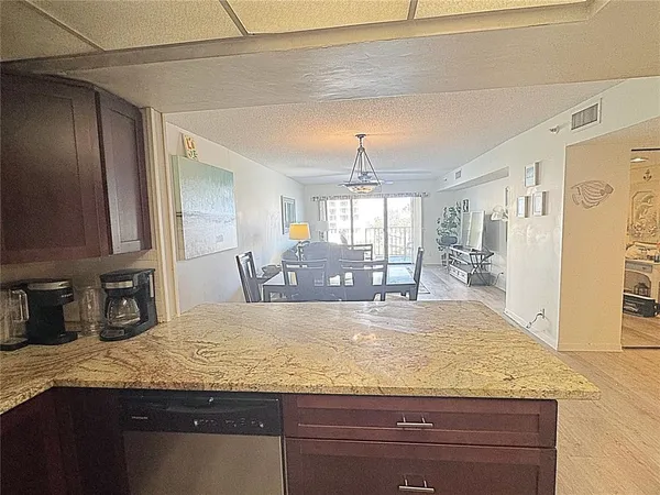 a view with granite countertop kitchen island a sink appliances and a counter top space