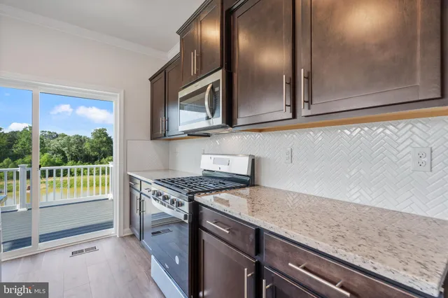 a kitchen with granite countertop cabinets stainless steel appliances and a counter space