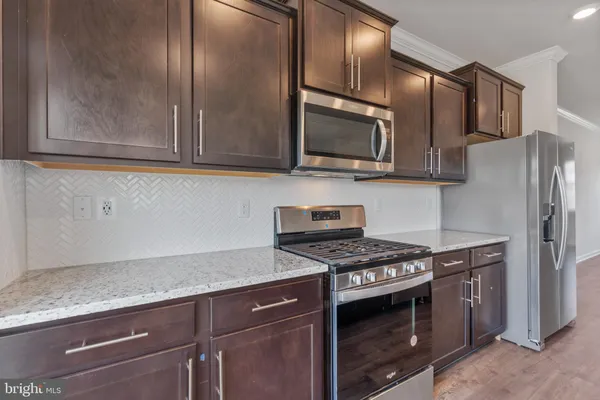 a kitchen with stainless steel appliances granite countertop a stove microwave and refrigerator