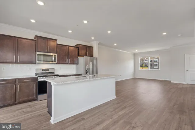 a kitchen with stainless steel appliances granite countertop a stove a sink and a refrigerator