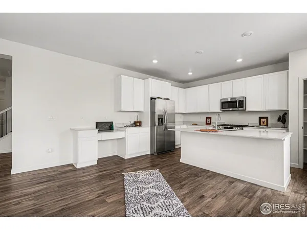 a kitchen with stainless steel appliances a refrigerator stove a sink and a oven with wooden floor