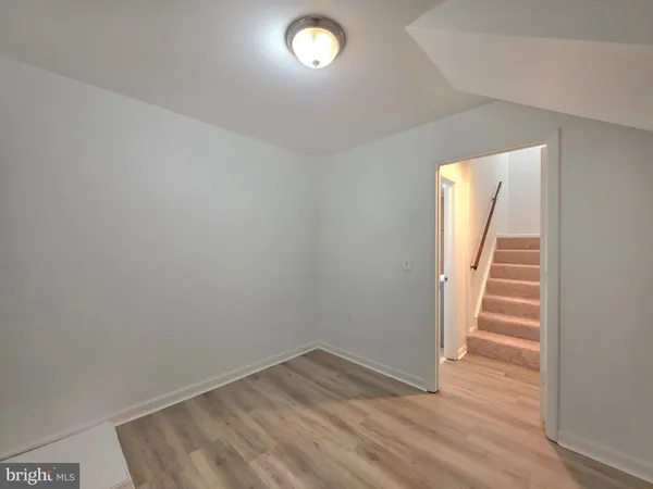 a view of empty room with wooden floor and fireplace