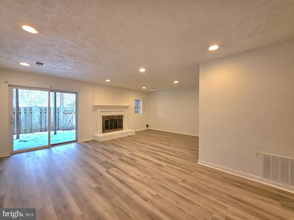 an empty room with wooden floor and a window