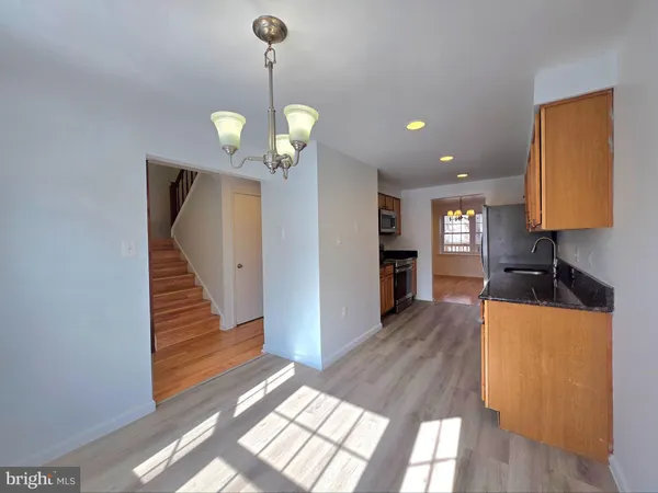 a view of a kitchen with furniture a ceiling fan and wooden floor