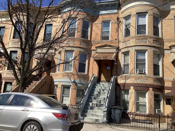 a view of a building with a cars side of road