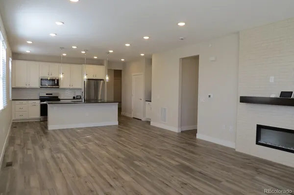 a large kitchen with stainless steel appliances granite countertop a stove a sink and a refrigerator
