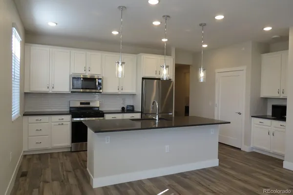 a kitchen with kitchen island a sink stainless steel appliances and cabinets