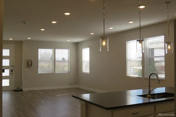 a kitchen with stainless steel appliances granite countertop a refrigerator a stove a sink dishwasher and microwave with wooden floor