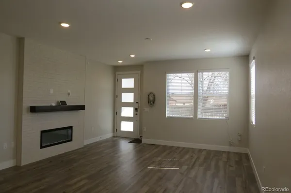 an empty room with a fan & a window