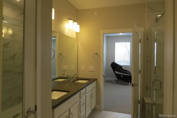 a en suite bathroom with a granite countertop sink and a mirror