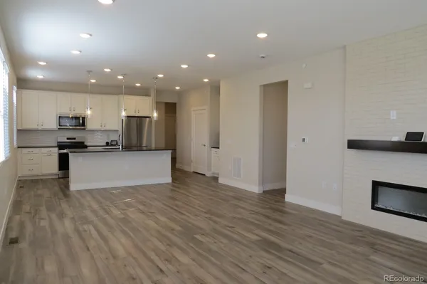 a view of kitchen view wooden floor and stainless steel appliances