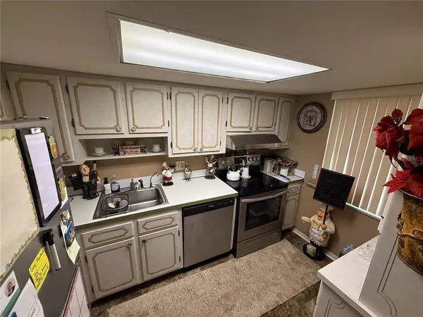 a kitchen with stainless steel appliances a stove a sink and cabinets