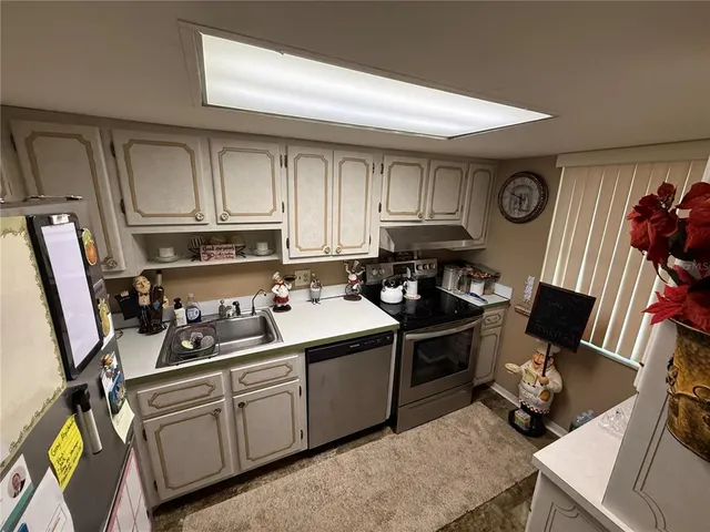 a kitchen with stainless steel appliances a stove a sink and cabinets