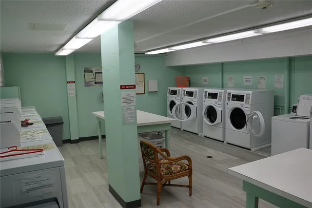 a utility room with dryer washer and stair