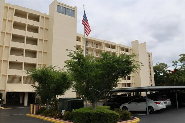 a front view of a building with parking space and a car park