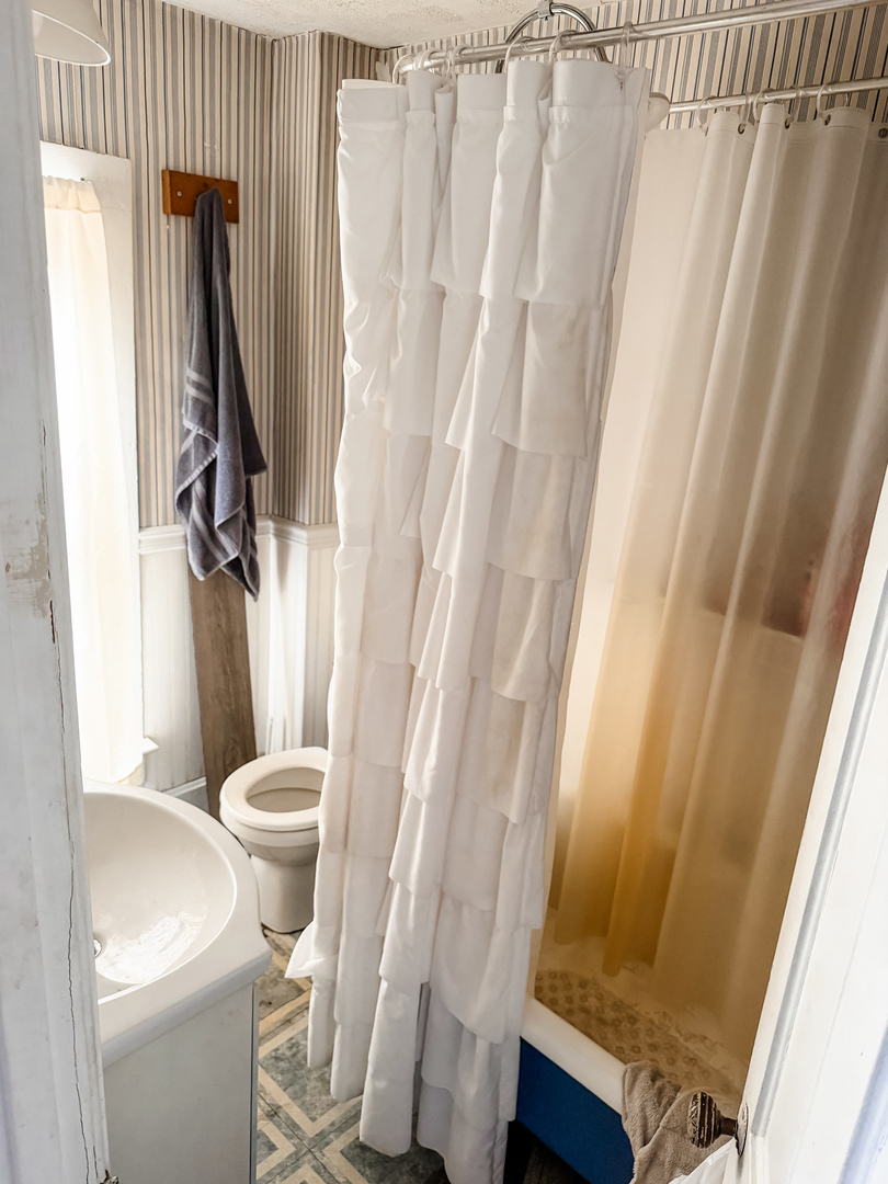 101 West Main Street Genoa, IL 60135 - Photo 5 of 5 a white toilet sitting next to a shower curtain