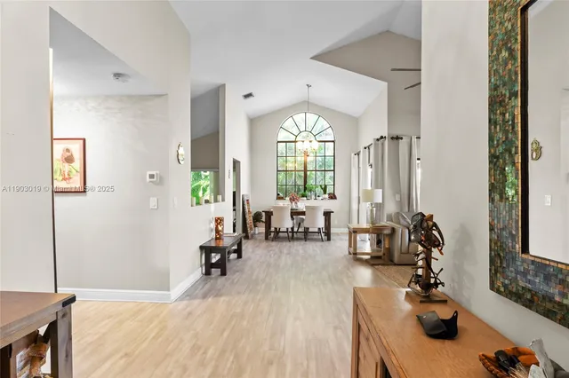 a living room with furniture hard wood floor and a large window