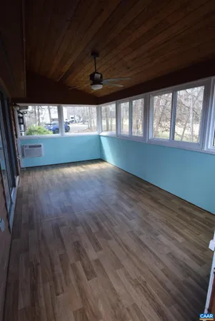 a view of an empty room with a window and a kitchen