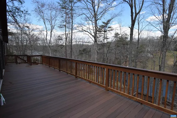 a balcony with wooden floor and trees