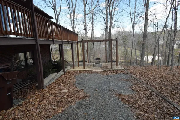 a view of a backyard with large trees and a small barn